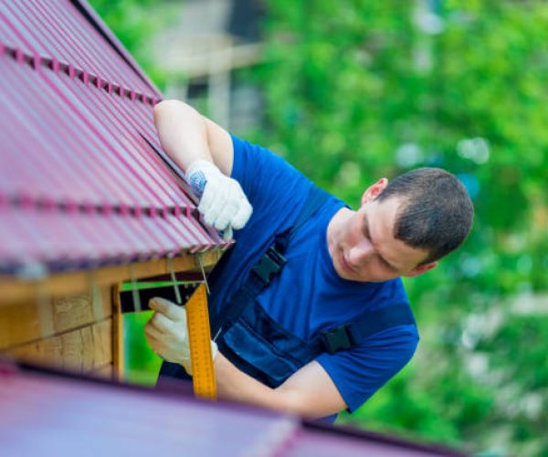 A man with a tool during the repair of the roof of the house