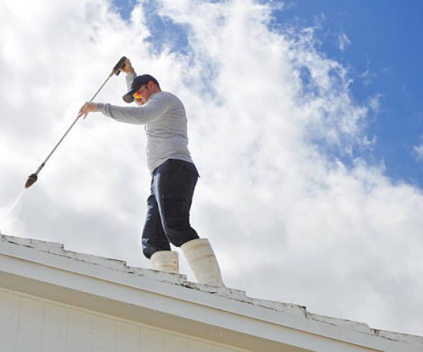 Handy man Pressure cleaning a roof.